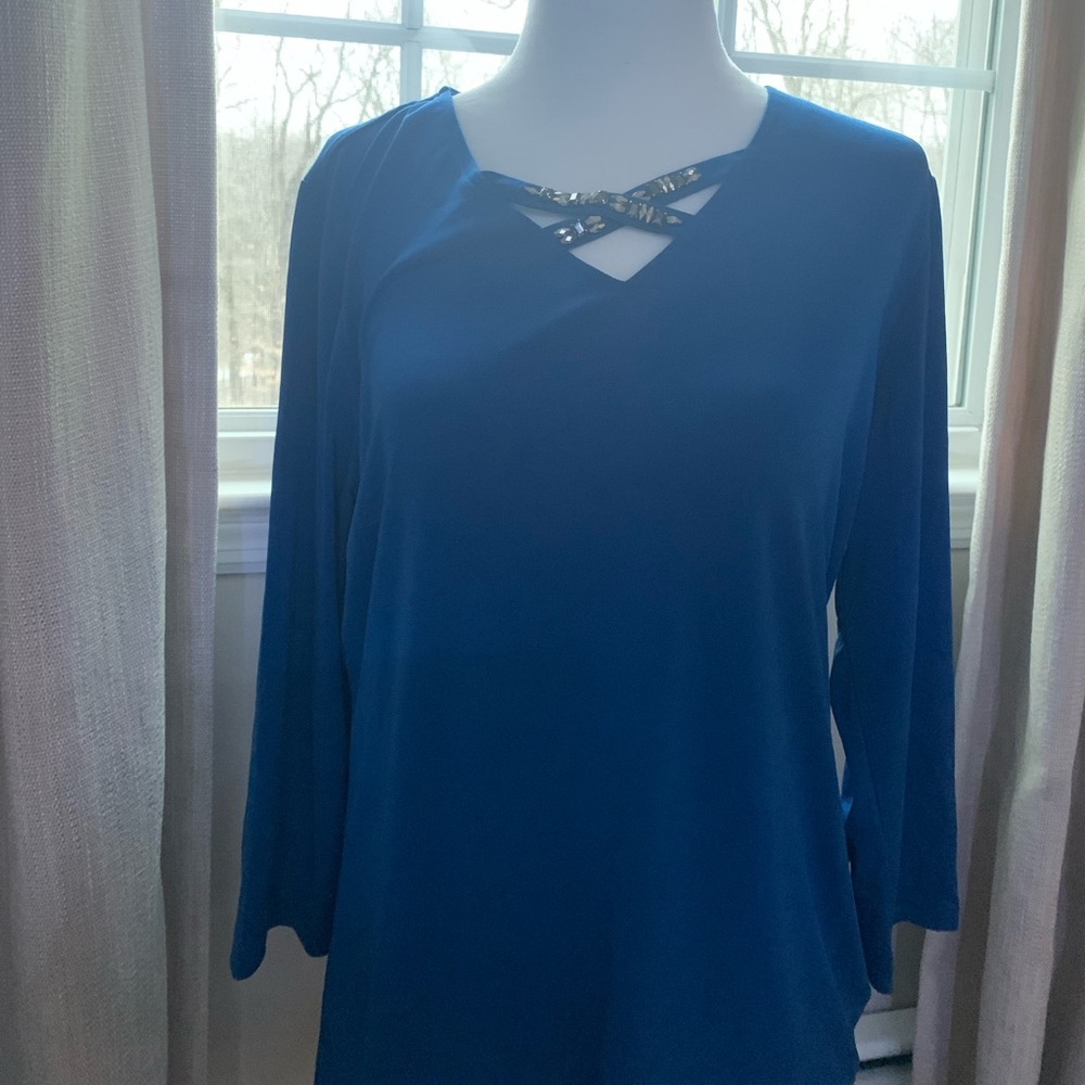 A blue top with a beaded cross design.